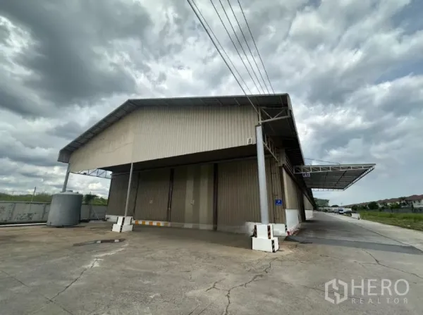 Warehouse for rent in Lat Krabang, Bangkok - Exterior view of a large metal-clad warehouse with covered loading bay and wide truck driveway in Lat Krabang.