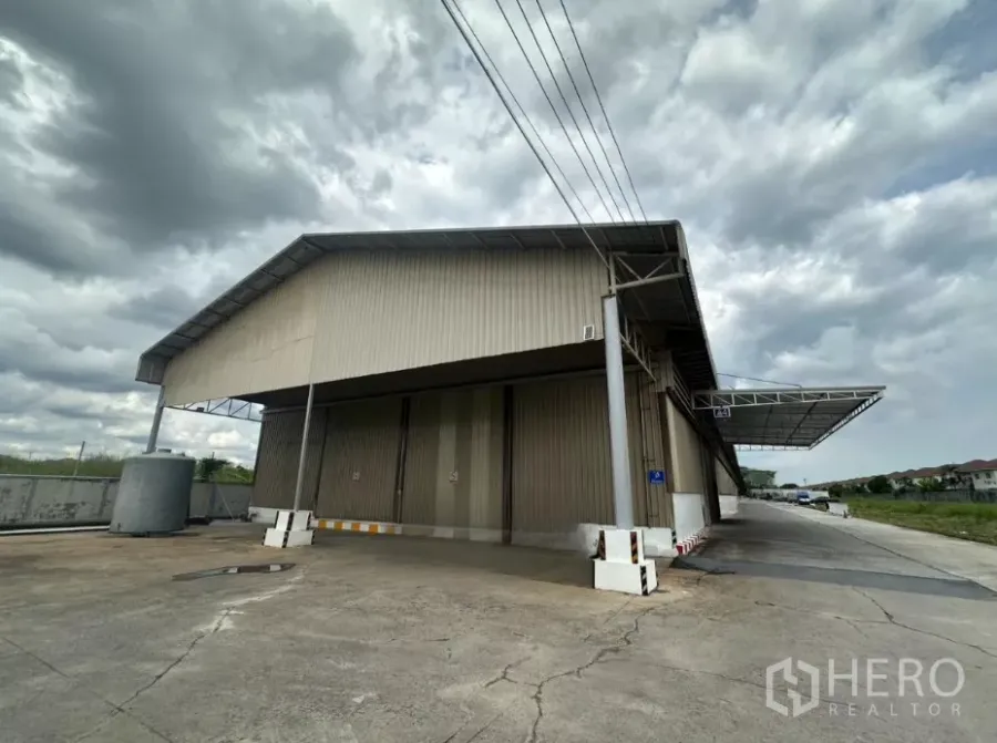 Warehouse for rent in Lat Krabang, Bangkok - Exterior view of a large metal-clad warehouse with covered loading bay and wide truck driveway in Lat Krabang.