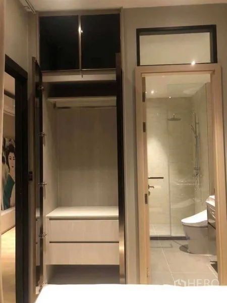 Condominium for rent in Watthana, Bangkok - Built-in wardrobe beside a glass-door bathroom with shower and toilet in a 1-bedroom Bangkok condo.