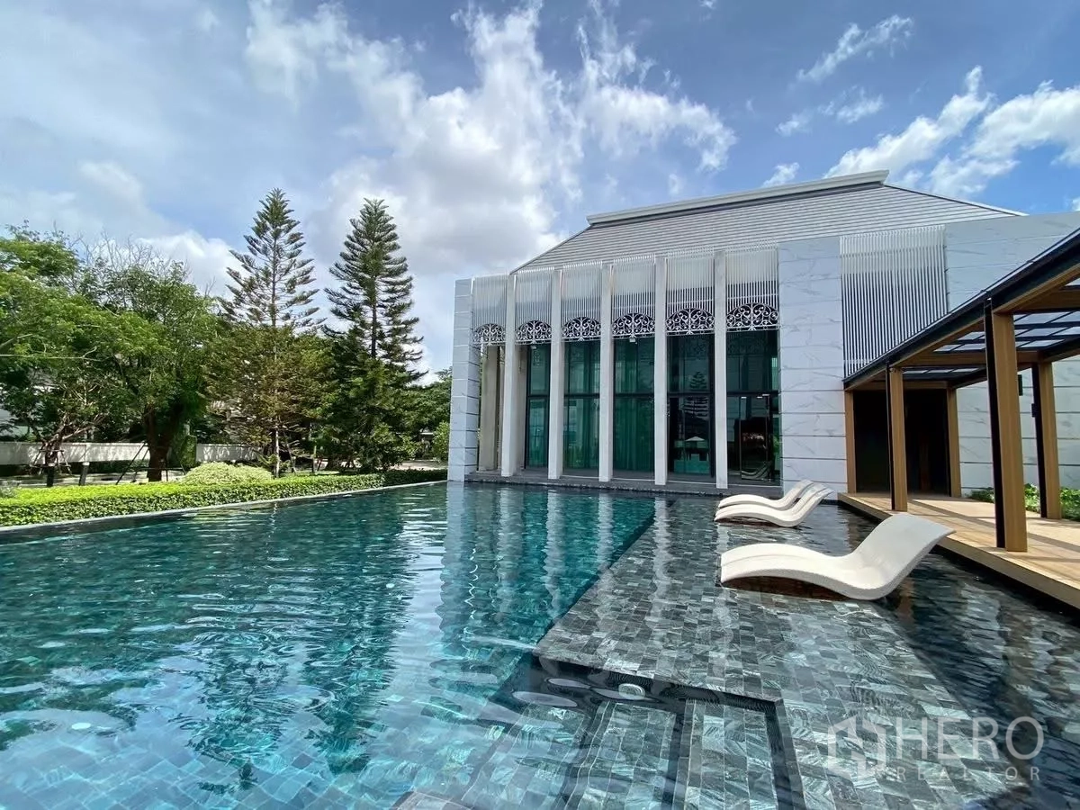 Detached House for rent in Bang Phli, Samut Prakan - Project clubhouse swimming pool with sun loungers and landscaped gardens.