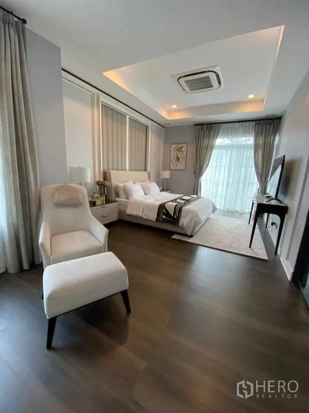 独立式住宅 出租在Bang Khen, Bangkok - 宽敞主卧，带起居区、造型吊顶与大窗帘。