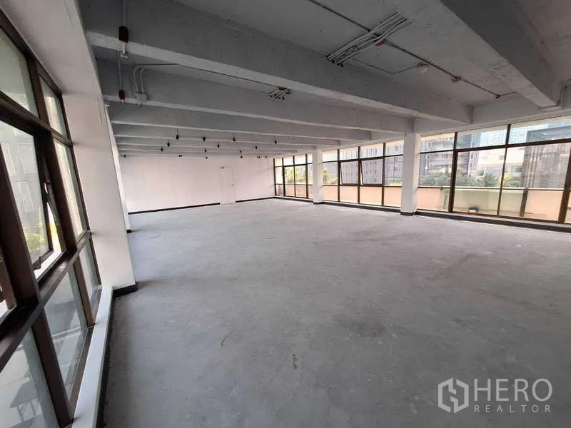 สำนักงาน ให้เช่า - โถงทำงานโล่ง เสาขวางน้อย ผนังสีขาว และหน้าต่างพาโนรามารับแสงธรรมชาติ