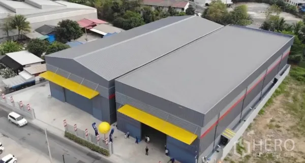 货栈 出租在Sai Mai, Bangkok - 俯瞰双跨工业仓库园区，黄色雨棚与围栏庭院，位于曼谷北部。