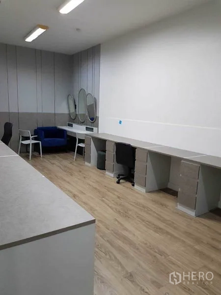 สำนักงาน ให้เช่าในKhlong Toei, Bangkok - มุมมองอีกด้านของห้องกั้น พร้อมโต๊ะทำงานยาวหลายตำแหน่งและที่นั่ง