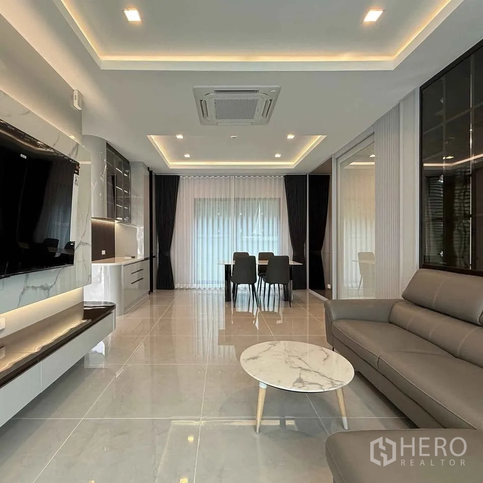 Detached House for rent in Bang Phli, Samut Prakan - View from sofa to TV wall, dining zone and full-height curtains.