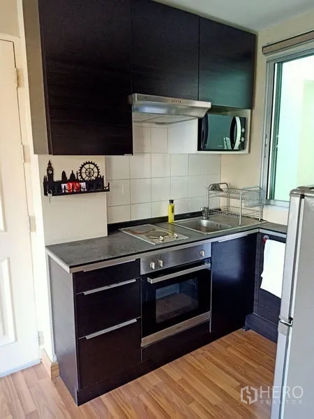 คอนโด ให้เช่าในKhlong Toei, Bangkok - ครัวพร้อมเตาอบ เตาไฟฟ้า ที่ดูดควัน และตู้แขวนบิลท์อินข้างหน้าต่าง