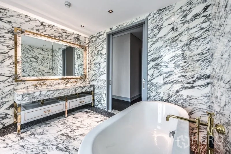 公寓 出租在Bang Rak, Bangkok - 奢华大理石浴室，独立浴缸、金色龙头与大框镜。