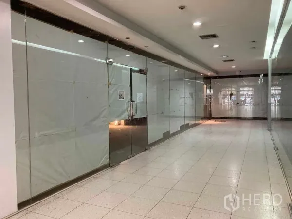 พื้นที่ขายปลีก ให้เช่า - หน้าร้านค้ากระจกเต็มบานว่างในโถงศูนย์การค้าภายในอาคาร พื้นกระเบื้องและไฟเพดาน