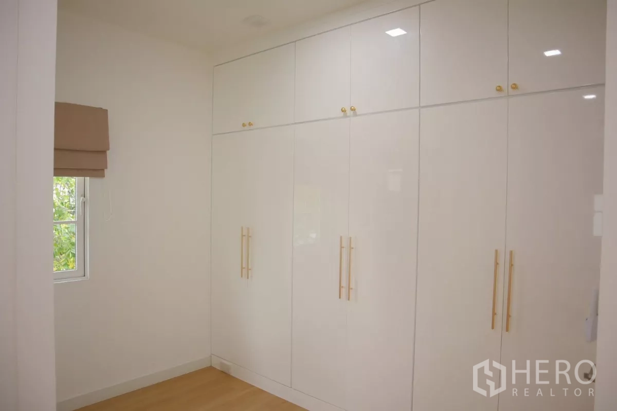 Detached House for rent in Bang Phli, Samut Prakan - Bedroom with full-height glossy wardrobes and wood flooring.