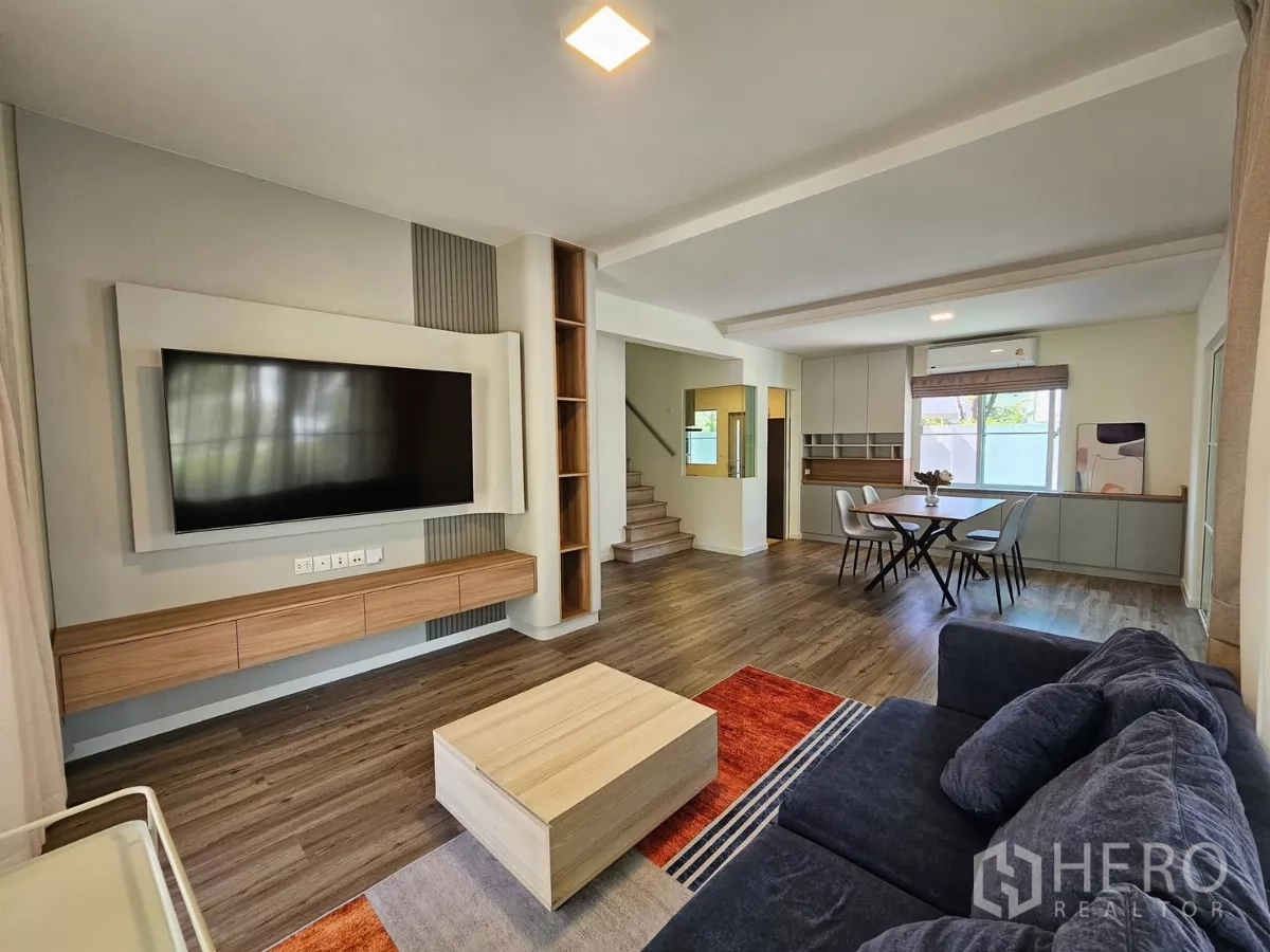 บ้าน ให้เช่าในBang Phli, Samut Prakan - ห้องนั่งเล่นและทานอาหารแบบโอเพ่น พร้อมผนังทีวีบิวท์อินและพื้นไม้