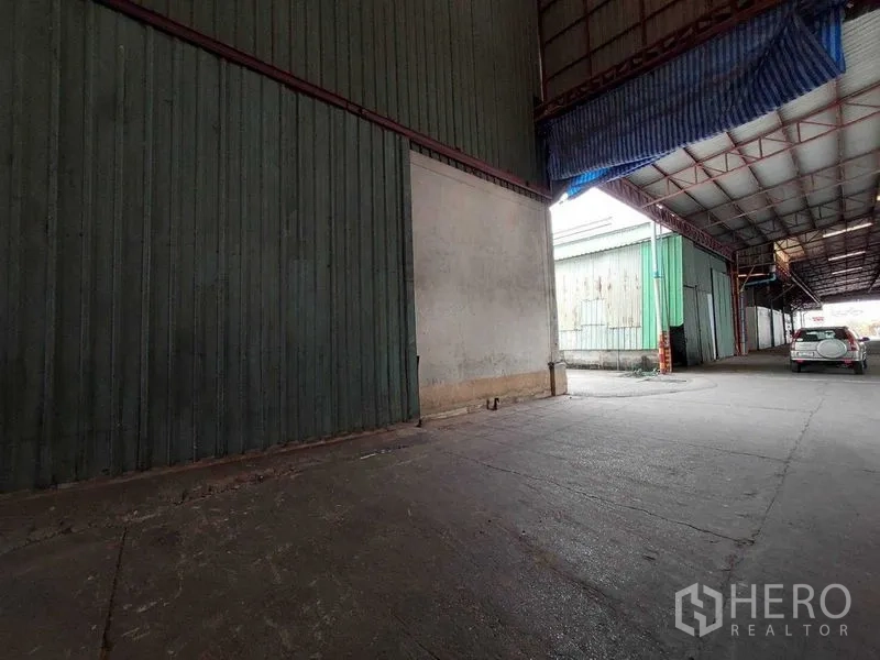 Warehouse for rent in Lat Lum Kaeo, Pathum Thani - Covered loading bay with high canopy roof and vehicle access lane.