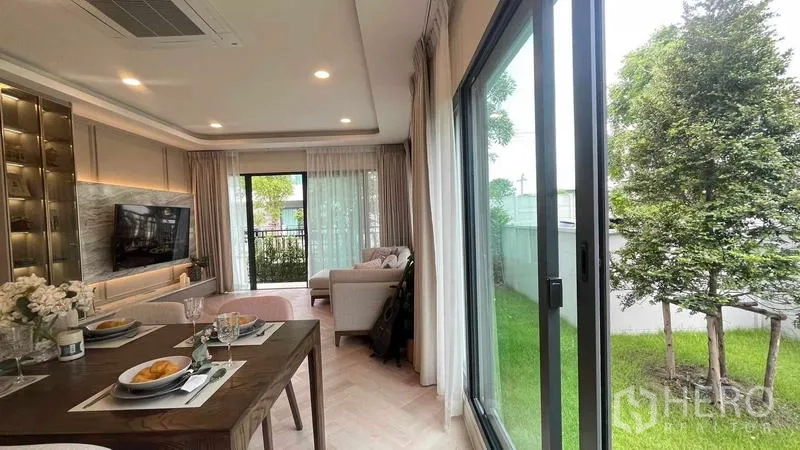 Detached House for rent in Bang Phli, Samut Prakan - Dining area opening to a green lawn through full-height sliding glass doors