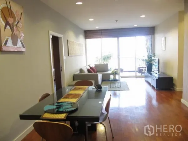 คอนโด ให้เช่าในKhlong Toei, Bangkok - เลย์เอาต์โอเพ่นแปลน แสดงโต๊ะอาหาร ไฟดาวน์ไลท์ และหน้าต่างสูงเต็มบานสู่ระเบียง