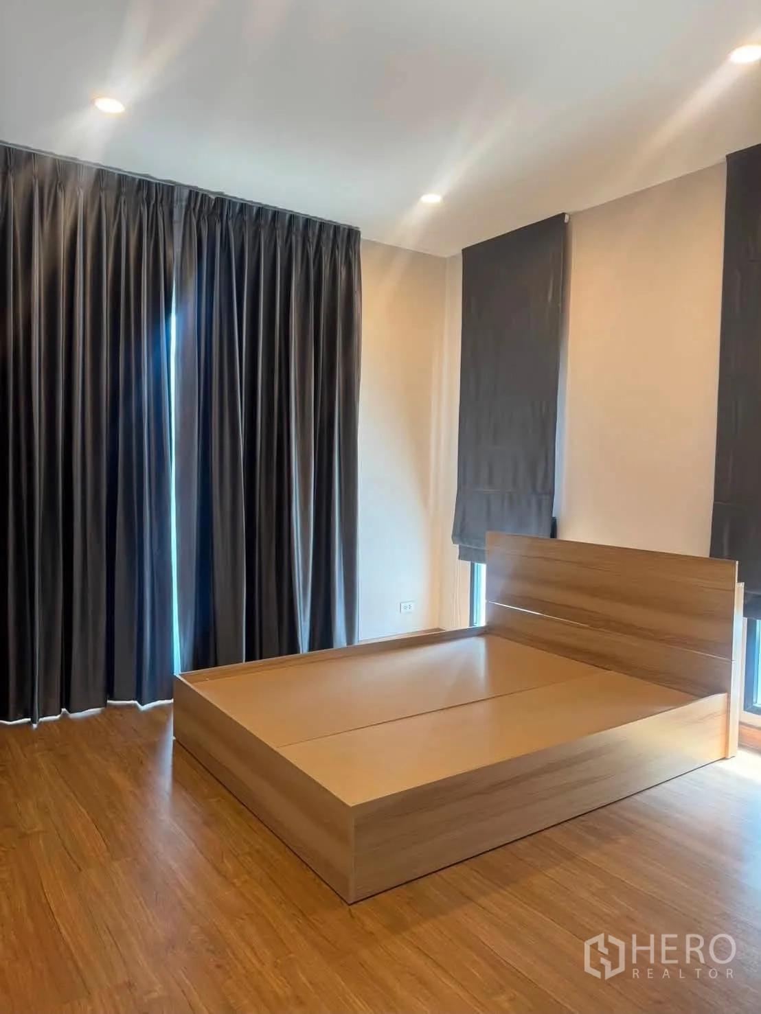 บ้านเดี่ยว for rent or sale in Prawet, Bangkok - ห้องนอนกว้างมีเตียงไม้ ผ้าม่านทึบ ไฟดาวน์ไลต์ และพื้นไม้