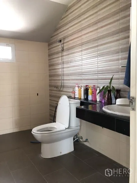 บ้าน ขายในLam Luk Ka, Pathum Thani - ห้องน้ำผนังลายริ้วพร้อมโถสุขภัณฑ์และอ่างล้างหน้า