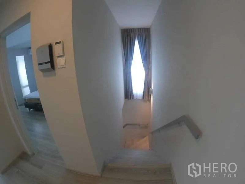 Townhouse for rent - Stair landing with natural light from a tall window leading to upper bedrooms.