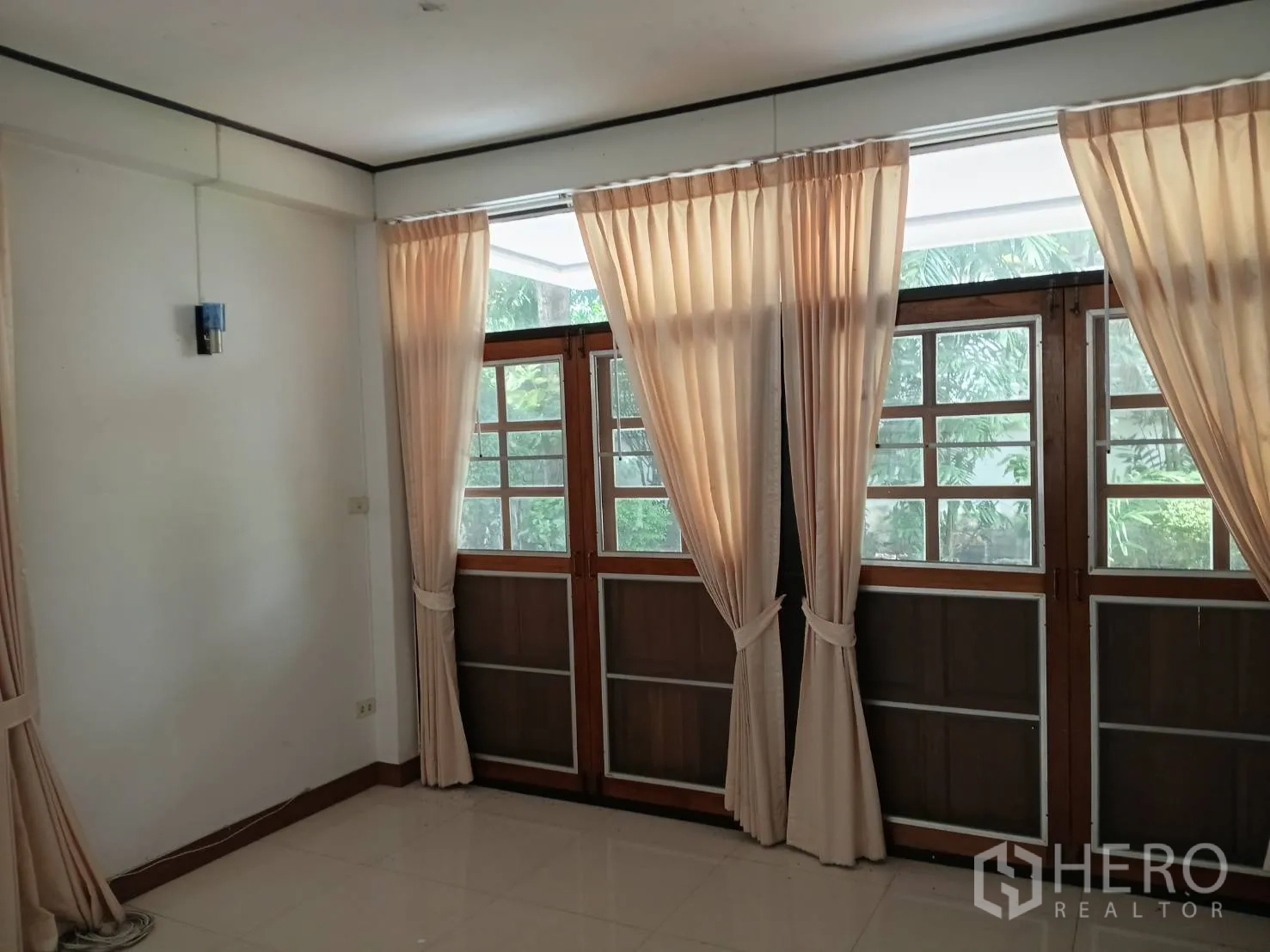 Detached House for sale in Watthana, Bangkok - Bright room with full-height wooden French doors and light curtains.
