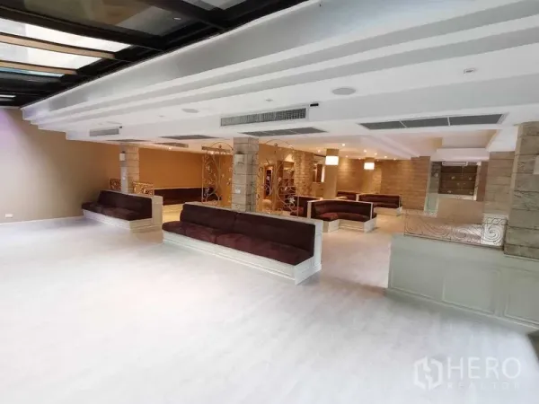 零售空间 出租在Pathum Wan, Bangkok - 宽敞开间展厅，内置弧形卡座、层次吊顶与暖色灯光。