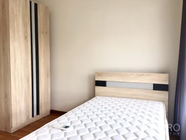 ทาวน์เฮาส์ ให้เช่าในPrawet, Bangkok - ห้องนอนอบอุ่นพร้อมตู้เสื้อไม้และที่นอนข้างหน้าต่าง.