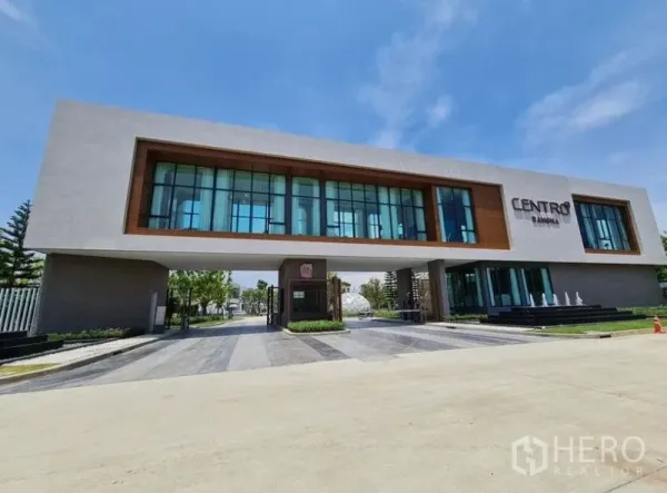 Detached House for rent in Bang Phli, Samut Prakan - Modern gated community entrance and clubhouse with glass facade labeled Centro Bangna.