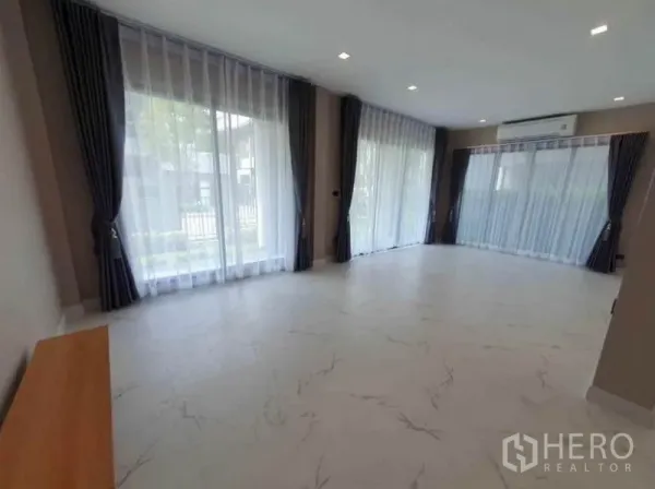 Detached House for rent in Lak Si, Bangkok - Spacious open-plan living area with wraparound glazing, air-conditioning and white marble-look flooring.