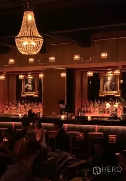 零售空间 出租在Watthana, Bangkok - 背光吧台，水晶吊灯与装饰画相映成趣。