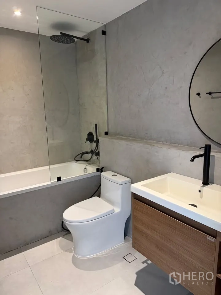 Condominium for rent in Watthana, Bangkok - Bathroom with bathtub, glass screen, rain shower, and wood vanity.