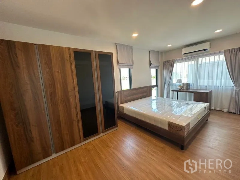 Detached House for rent in Bang Phli, Samut Prakan - Guest bedroom featuring large sliding-door wardrobe, air conditioner and abundant daylight.