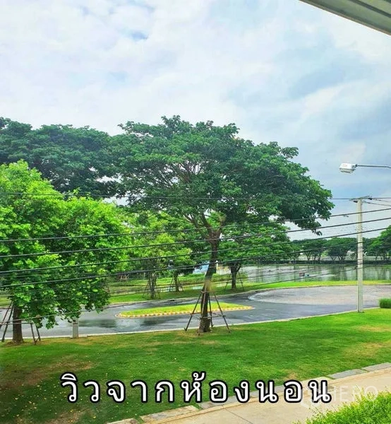 Detached House for sale in Samut Prakan - Leafy view of trees, road and lakeside seen from an upper-floor bedroom.