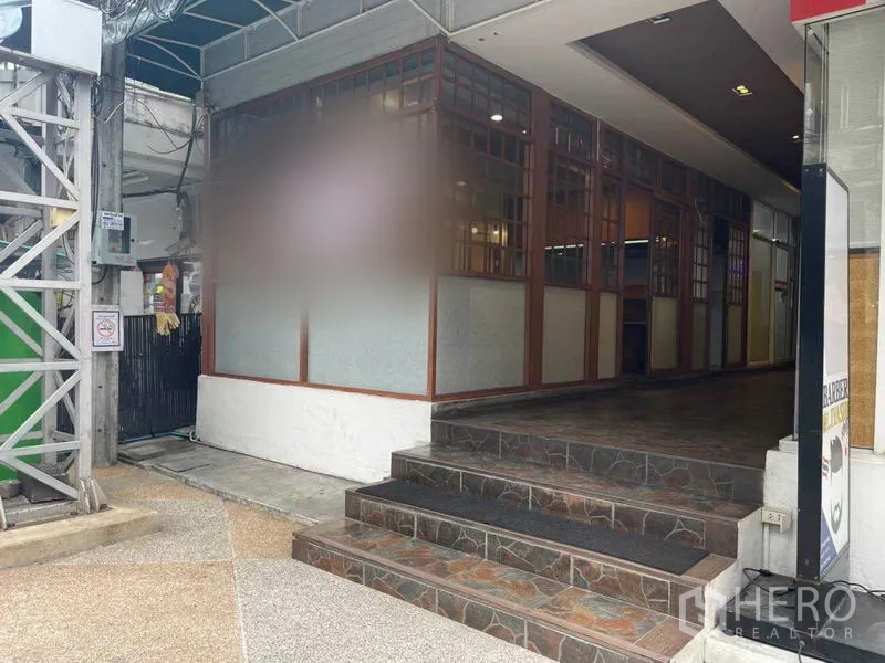 พื้นที่ขายปลีก ให้เช่าในWatthana, Bangkok - ทางขึ้นบันไดสู่ห้องมุม หน้าร้านกระจกกรอบลูกกรงใต้กันสาด ในย่านพร้อมพงษ์