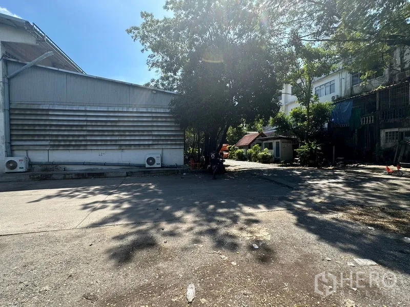 Warehouse for rent in Suan Luang, Bangkok - Outdoor yard beside the warehouse with shade trees providing ample truck turning and parking space.