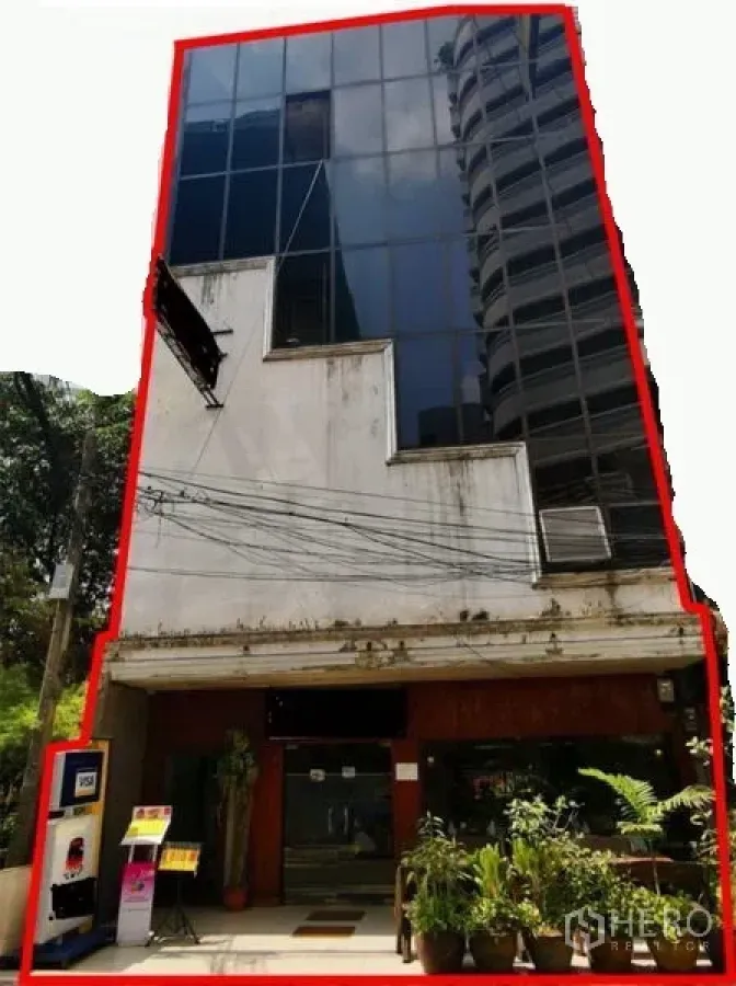 零售空间 出租或出售在Watthana, Bangkok - 素坤逸–阿索克区域的五层玻璃幕墙商业楼，底层店面入口配绿植，靠近BTS Asok。