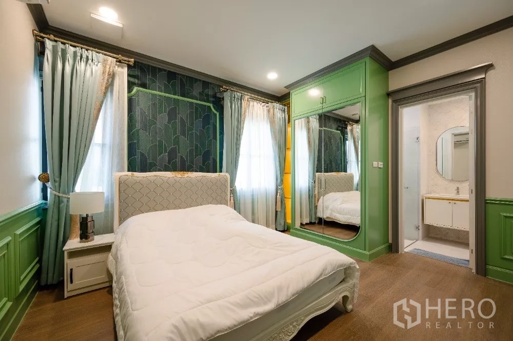 Detached House for rent or sale in Khlong Toei, Bangkok - Cozy bedroom with green built-in wardrobes, mirrored doors and an ensuite bathroom.
