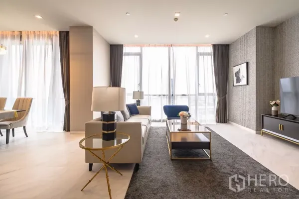 公寓 出租在Watthana, Bangkok - 明亮客厅面向餐区，大窗户、电视柜与中性配色。