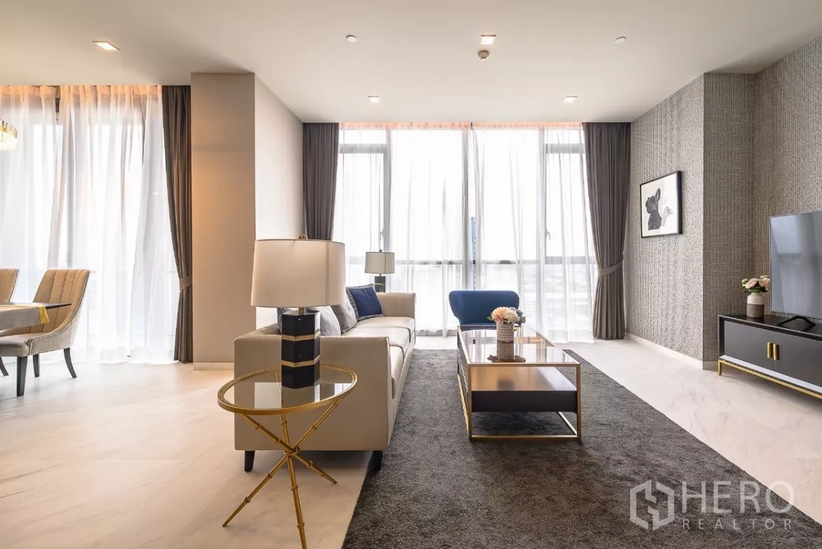 公寓 出租在Watthana, Bangkok - 明亮客厅面向餐区，大窗户、电视柜与中性配色。