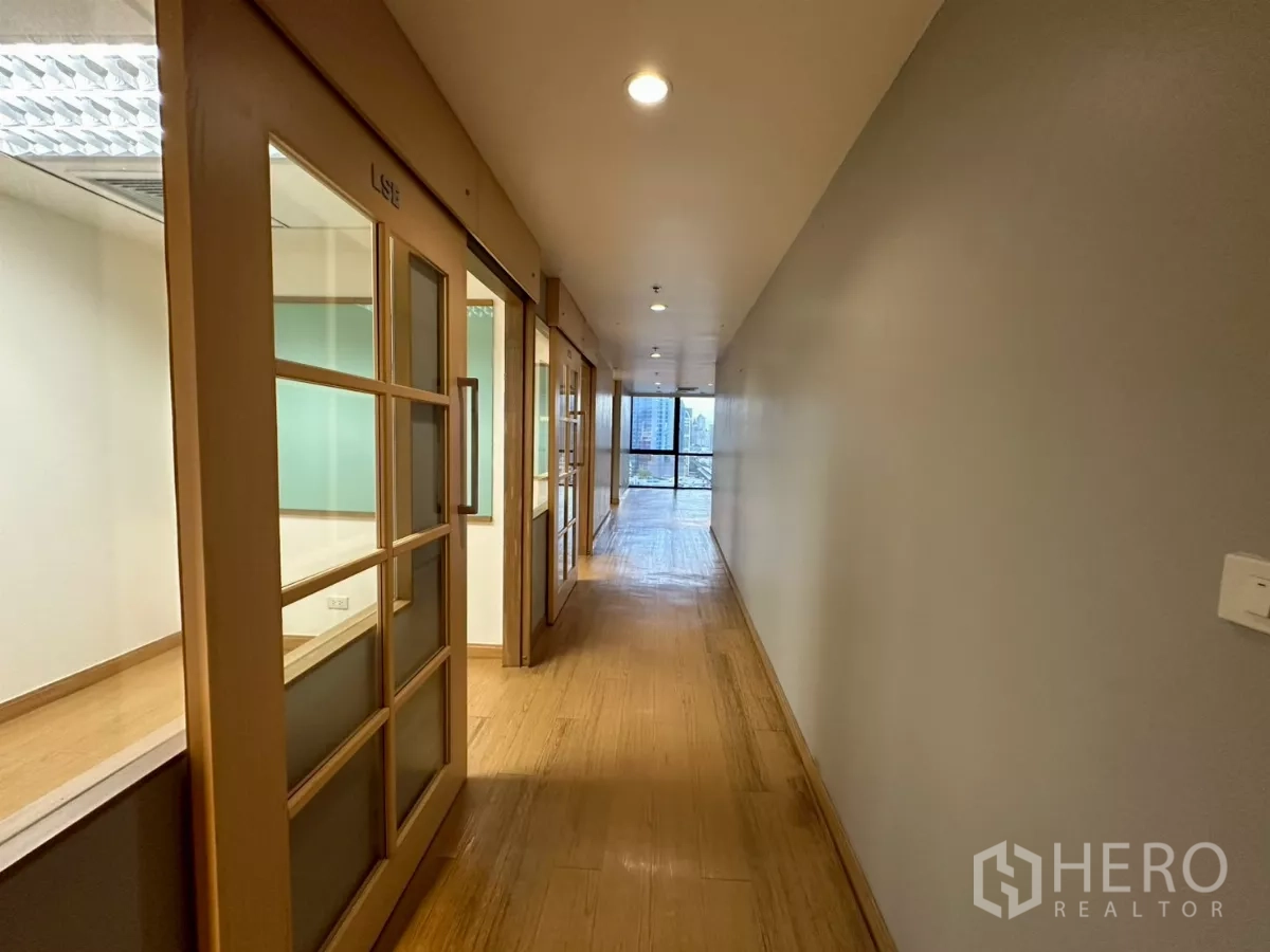 Office Space for rent in Khlong Toei, Bangkok - Long corridor with labeled sliding doors to private rooms and a window at the end.