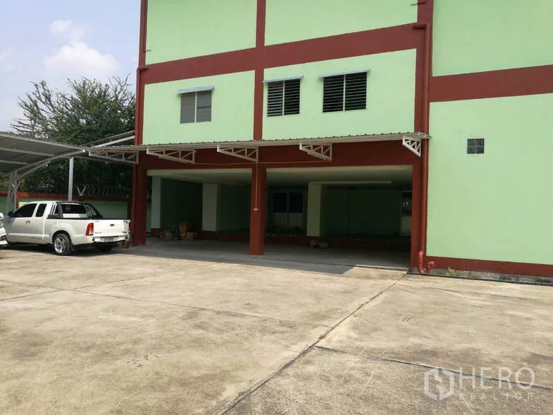 Factory for rent in Mueang Samut Sakhon, Samut Sakhon - Secure gated entrance and perimeter fence of the factory compound on a quiet road.