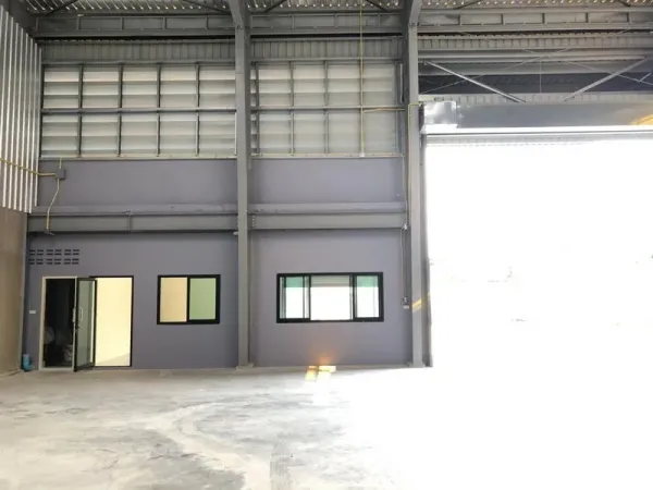 工厂 出租在Khlong Luang, Pathum Thani - 厂房内部，底层办公室置于高钢结构屋顶下，旁有大型卷帘门。
