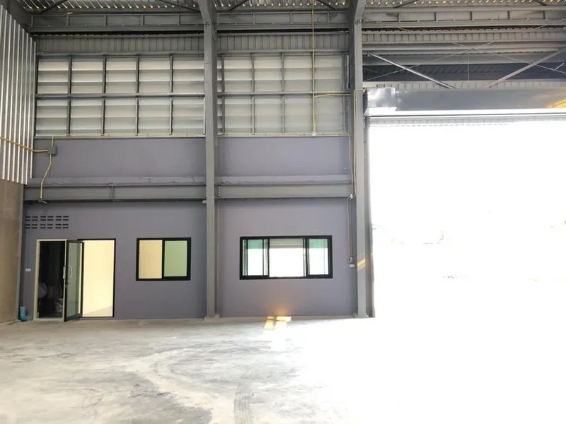 工厂 出租在Khlong Luang, Pathum Thani - 厂房内部，底层办公室置于高钢结构屋顶下，旁有大型卷帘门。