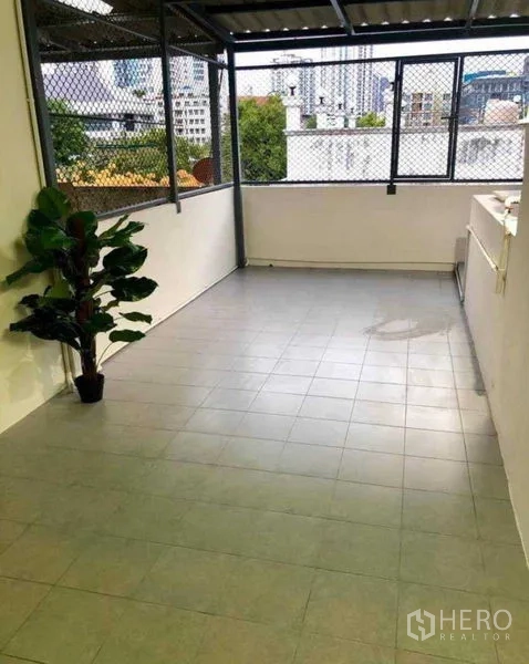 Home Office for rent or sale in Watthana, Bangkok - Covered rooftop terrace with tiled floor, mesh windows and city outlook.