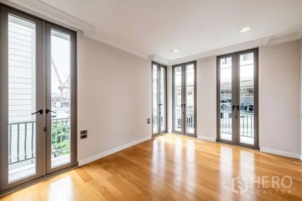 ทาวน์เฮาส์ ให้เช่าในKhlong Toei, Bangkok - ห้องสว่าง พื้นไม้ และประตูหน้าต่างกระจกสูงรอบด้าน