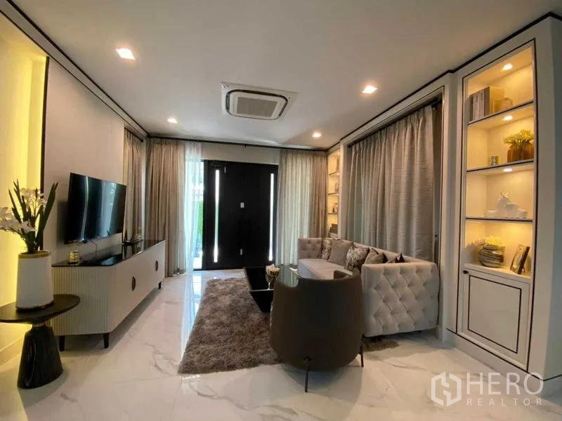 独立式住宅 出租在Bang Khen, Bangkok - 现代客厅，电视墙、嵌入式展示柜与落地窗帘。