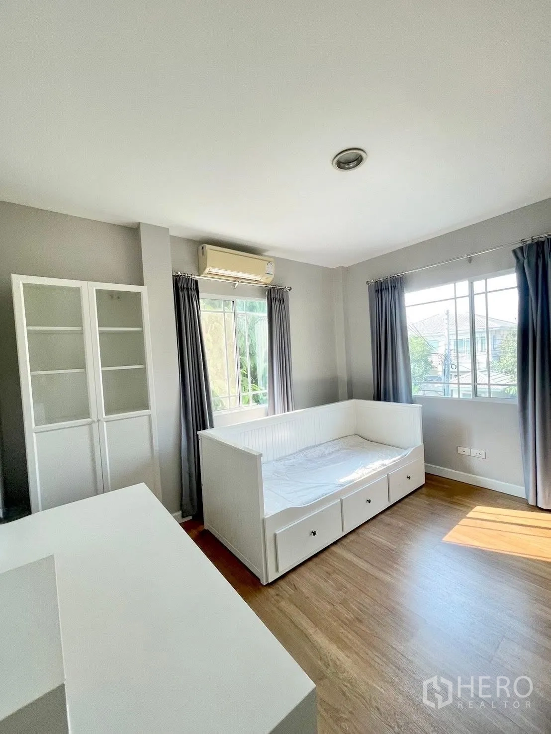 独栋房屋 for rent in Prawet, Bangkok - 多功能房，白色日间床、玻璃柜与空调。