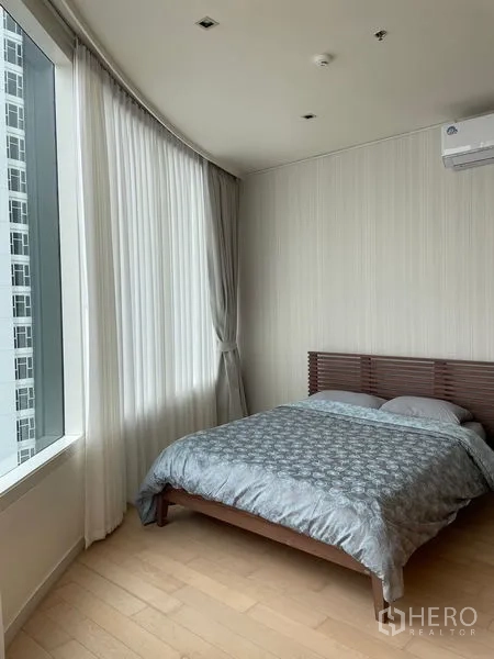 คอนโด ให้เช่าในWatthana, Bangkok - ห้องนอนหลักพร้อมหน้าต่างบานใหญ่ เครื่องปรับอากาศ และเตียงไม้