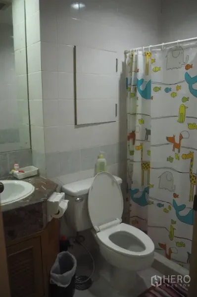 คอนโด ให้เช่าในPathum Wan, Bangkok - ห้องน้ำปูกระเบื้อง อ่างล้างหน้า โถสุขภัณฑ์ และพื้นที่อาบน้ำพร้อมม่านลายการ์ตูน