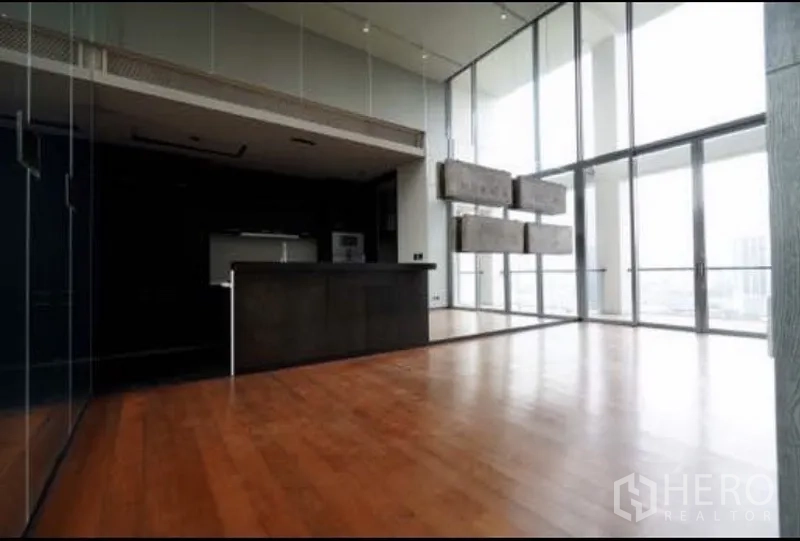 公寓 出租在Sathon, Bangkok - 开放式客餐厅，带厨房岛台与整面落地窗，通透明亮。