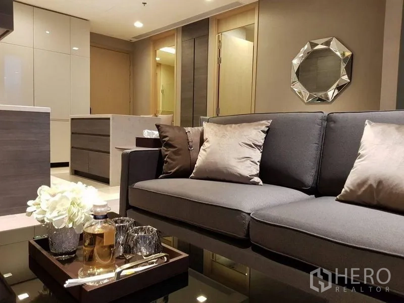 Condominium for rent in Watthana, Bangkok - Close-up of lounge sofa with cushions and a tray on a glossy coffee table.