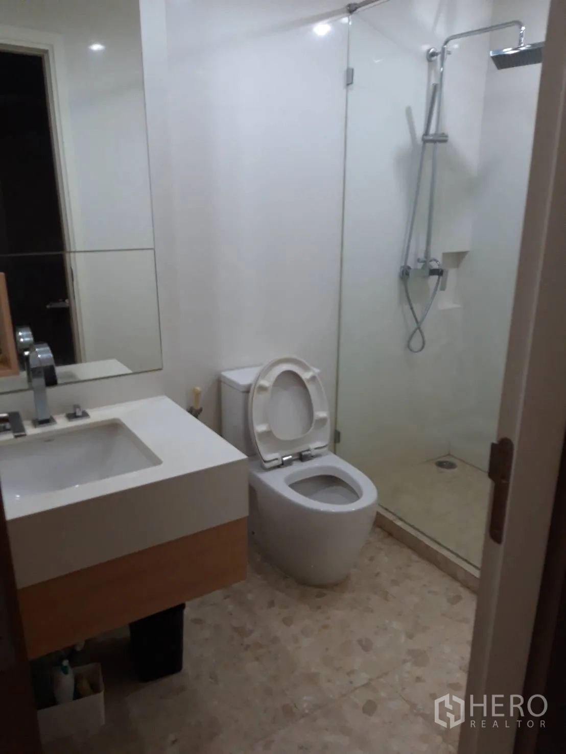 Condominium for rent in Watthana, Bangkok - Modern bathroom with glass-enclosed shower, vanity and toilet.