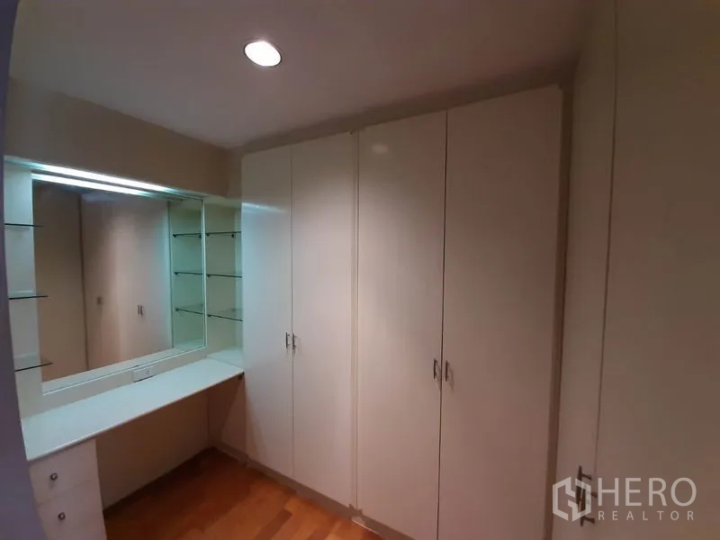 公寓 出租或出售在Watthana, Bangkok - 步入式衣帽间，内置衣柜、梳妆台与大镜子。