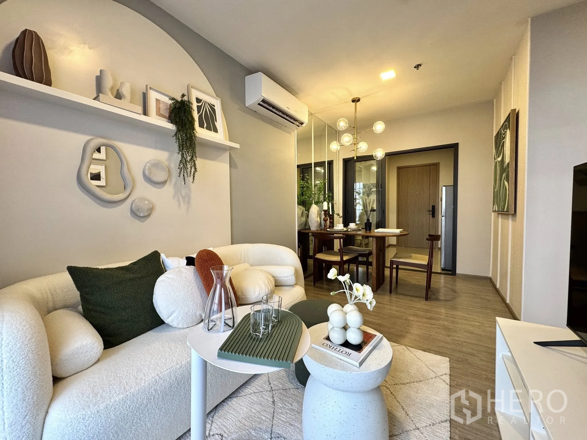 公寓 for rent in Watthana, Bangkok - 从沙发望向餐区与入户门，装饰置物架与现代灯具点缀。